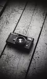 the old style camera is on a wooden surface