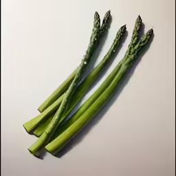 several green asparagus with leaves laying on top of a white surface