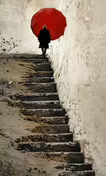 person standing on stairs holding an open umbrella