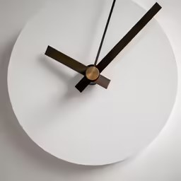 a white round clock with black hands and two circles