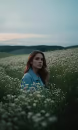a woman is sitting in a field with tall grass