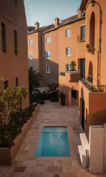 an empty courtyard and pool with a large building behind