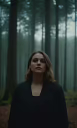 a woman standing in the woods with trees