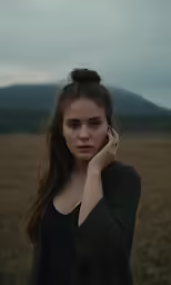 a woman standing in front of a large grassy field