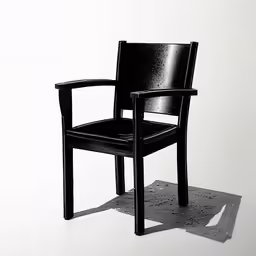 the shadow of a black chair against a white wall