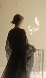 a woman in black dress holding white box with clouds in it