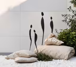 a group of pillows sitting on top of a bed next to a plant