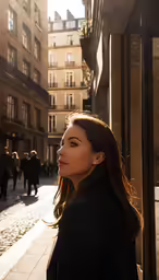 a beautiful young woman standing on the sidewalk