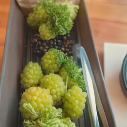 grapes, carrots, and other fruits lay together in an empty bin