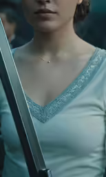 the young woman is holding her sword and looking ahead