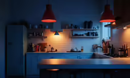 a kitchen with a stove and two lights on the ceiling