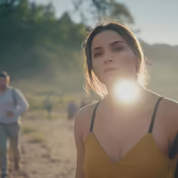 the young woman is looking at something while standing outside