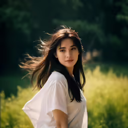 a young lady is standing in a field