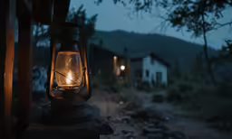 a lantern on a post next to a dirt road