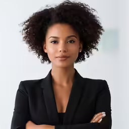 an african american female in a black suit standing arms crossed