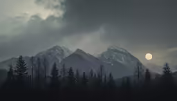 a group of mountains with dark trees against a cloudy sky