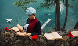 there is a woman that has her book on her lap