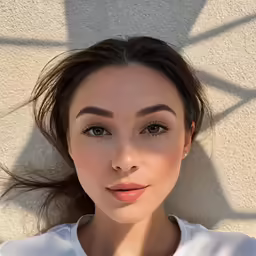 woman posing in a white blouse for a selfie