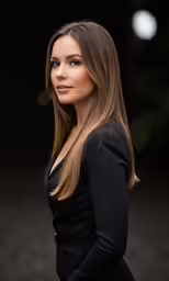 beautiful woman with long hair in black dress looking at camera