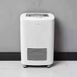 a white air purifitor sitting against a wall