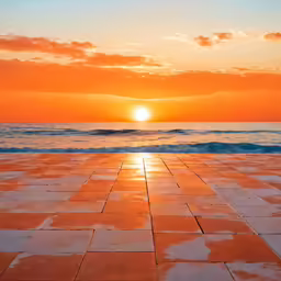 a sunset over an empty beach with the sea in the background