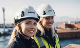 two woman in hard hats posing for a photo
