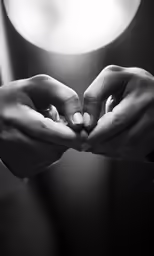 the hands are holding the ring in a black and white photo