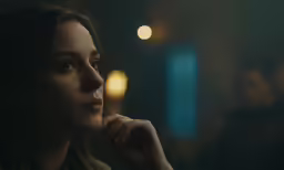 a young woman is staring into the distance