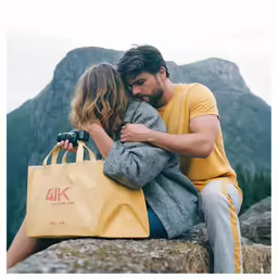 a couple is on top of the mountain and are hugging each other