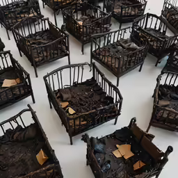 many pieces of small metal baby cribs and their baby beds