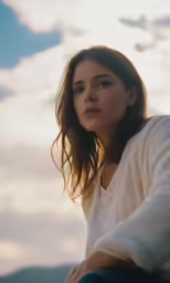 a woman sitting on the ledge of a high building