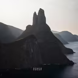 a boat floating in the ocean next to mountains