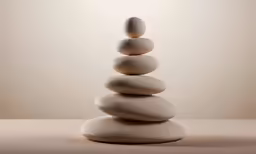 three white rocks stacked with one another on a beige surface