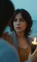 a woman lighting a candle beside a man
