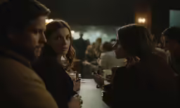 people standing around a table in a bar