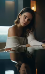 a woman is sitting with her arms folded over the shoulders of her body