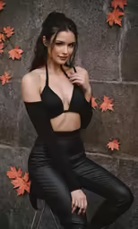 a woman posing in black leather pants and bra