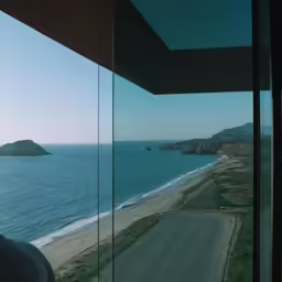 a view from the inside of a glass building looking out onto the water