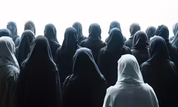 group of women standing together with hoods on