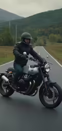 the man is sitting on the motorcycle on the road