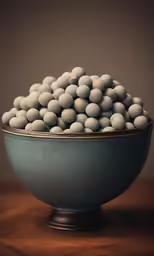 a green bowl filled with white balls on top of a table