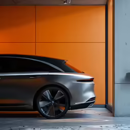 a silver car sitting next to a yellow wall