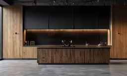 a kitchen with a counter and stools next to a window