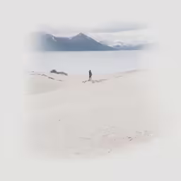 the lone person walks on the large snow - covered mountains