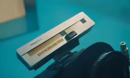 a view of a close up of an electronic device with lens, pen and flash drive