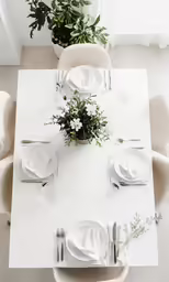 a close up shot of a table setting with white chairs