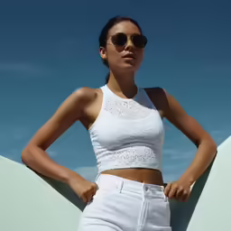 young woman standing on roof holding hand over hip