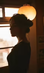 a beautiful woman standing in front of a window with a light shining on her face