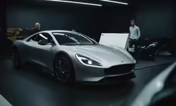 a man standing next to a white car on display