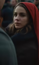 the woman in a hooded jacket is looking to her left